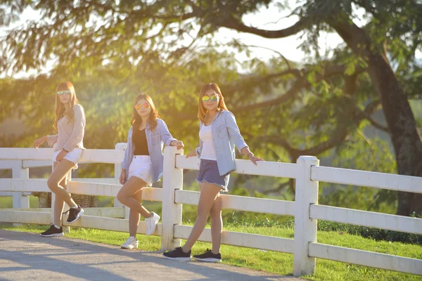 Hermosas chicas asiáticas tumbadas en la hierba verde bajo la luz del sol — Foto de Stock