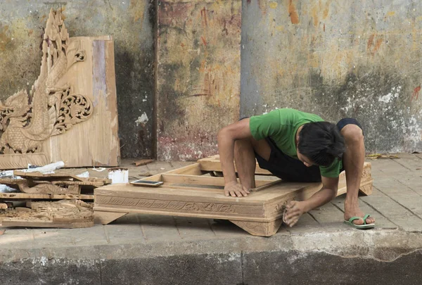 Неизвестный плотник, работающий на древесине по тротуару вдоль дороги к пагоде Шведагон — стоковое фото