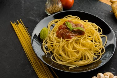 Spagetti domates sosu ve onların malzemeleri çevresinde. Ayarlamak