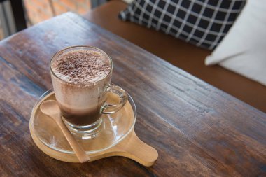 Şeffaf cam sıcak çikolata masada ahşap tepsi.