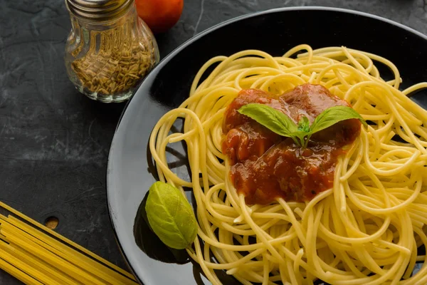 Spagetti domates sosu ve onların malzemeleri çevresinde. Ayarlamak