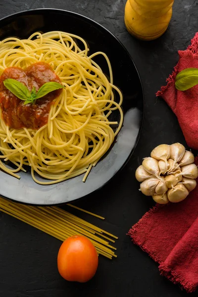 Спагетті з томатним соусом та їх інгредієнтами навколо — стокове фото