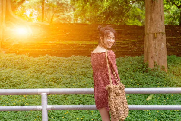 Asiatique cheveux longs dame regarder en arrière et grand sourire, robe rouge décontracté — Photo