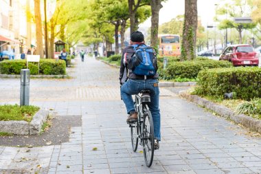 Yaşlı adam binmek bisiklet Japonya, yol boyunca ayak yolda iyileşmek