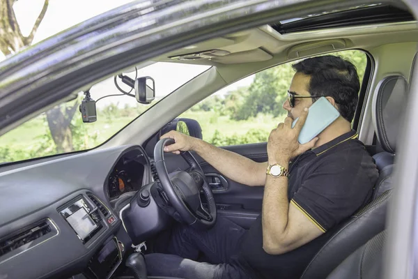 Casual hombre de negocios sentarse en el coche y hablar con el teléfono inteligente, coche p — Foto de Stock
