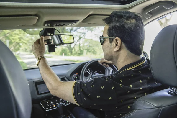 Asiático casual negocios hombre sentarse en coche y set medio espejo mientras — Foto de Stock