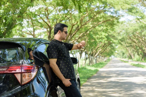 Homem de negócios casual muçulmano encostado à porta do carro e olhar para — Fotografia de Stock