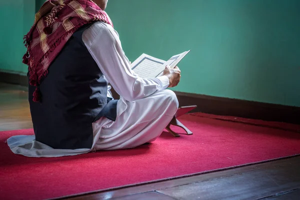 Islam uomo musulmano in abito musulmano lettura libro sacro del Corano su s — Foto Stock