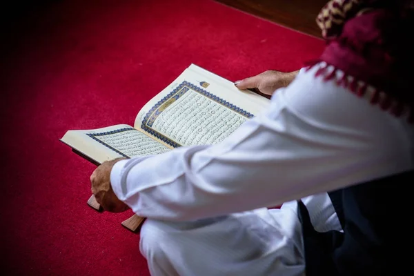 Islã muçulmano homem em vestido muçulmano leitura livro sagrado do Alcorão em s — Fotografia de Stock