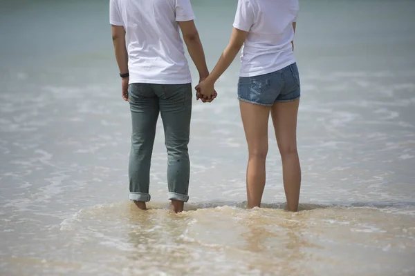 Junge asiatische Paar halten Hand zusammen stehen am Strand Blick auf die — Stockfoto