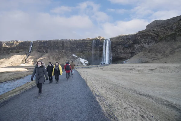 Путешественник прогулки по тротуару на Seljalandfoss водопад Исландии победить — стоковое фото