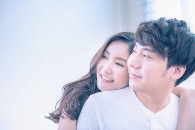 Yatakta sırtüstü uzanan Asyalı genç bir çiftin portresi olan kadın yüzü, yatakta otururken kucaklaşan romantik Asyalı insanlar, fotokopi uzayıyla sevgililer günü konsepti. Pastel post süreci..