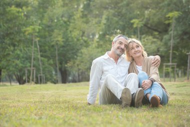 Kıdemli Kafkasyalı çift sonbaharda parkta birlikte oturuyorlar. Kadın, kocasının başının üstünde dinleniyor ve ellerini erkeğin dizine koyuyor. Güzel bir aşk ilişkisi ve emeklilik bakımı. Yaşlılar..