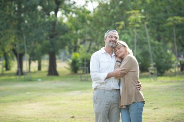 Bisikletleriyle parkta dolaşan neşeli, aktif, son sınıf çifti. Emeklilik hayatı süren yaşlılar için mükemmel etkinlikler.