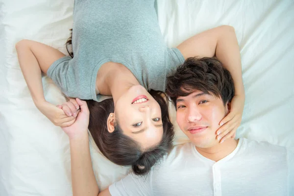 Portrait rapproché de joli jeune couple asiatique avec bonheur. asiatique homme et femme couché sur le lit face à la caméra avec grand sourire main toucher visage, amour émotion avec Valentine concept  . — Photo