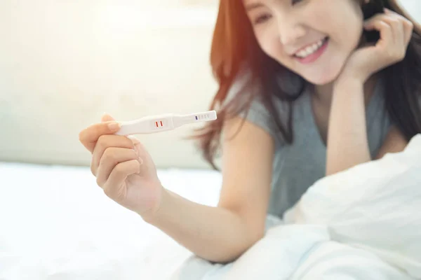 Selective focus on tester.Expecting mom with cheerful face with pregnancy in hand. — 스톡 사진