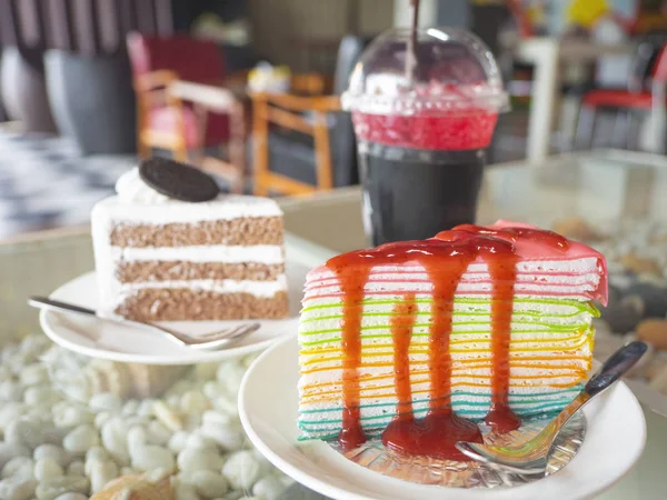 Close up of rainbow strawberries crape cake ,white chocolate cake and red juice on glass desk. — Stock Photo, Image