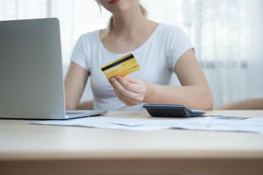 Mutlu, genç, beyaz bir kadın, kredi kartı taksitlerini online alışveriş ve müşteri hizmetleri ağ bağlantısı pazarında kullanıyor. Bilgisayarda internet e-ticaret teknolojisi kullanıyor..