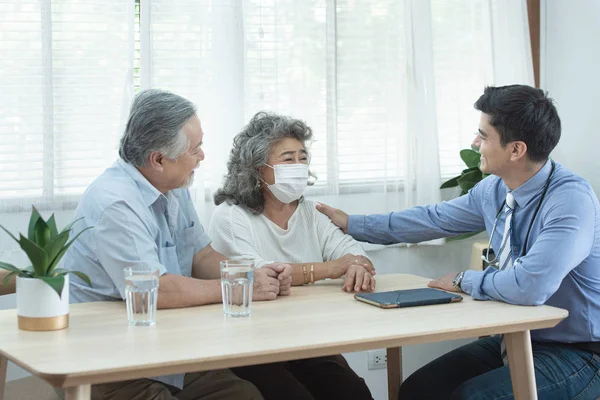 Elder senior old asian couple meeting  specialist professional caucasian doctor visit at home consultant two retirement patient after checkup,health care and medical concept. — Stock Photo, Image