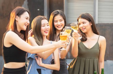 Asyalı çoklu cinsiyetli bir grup ellerinde şarap kadehiyle arkadaşlarıyla sohbet ederken açık hava gece klübünde dans partisini kutluyorlar. Genç arkadaşlıktan keyif alan eğlenceli yaşam tarzı..