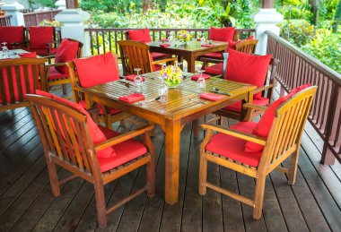 Hindistan 'da düğün resepsiyonunda ahşap yemek masasında cam vazoda süslü güzel bir orkide dekoru..