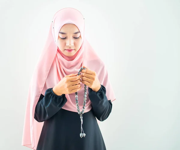 Half length side view of asian young beautiful muslim woman prayer dress hijab pray meditation in mosque for eid mubarak life and soul fasting of international islamic ramadan Namaz.