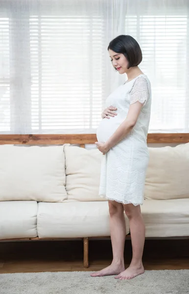 근처에 아이가서 전형적 아시아인 임산부 소녀는 아기에 기대를 가지고 있으며 — 스톡 사진