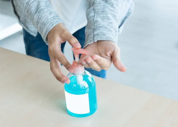 hands using wash hand sanitizer gel pump dispenser.Clear sanitizer pump bottle,for killing germ, bacteria and protect from coronavirus or covid-19 virus world pandemic,health care and medicine concept