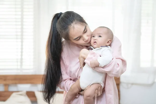 親の概念 幸せな美しい若いアジアの母親は彼女の腕の中で新生児を抱えて抱きしめる笑みを浮かべています 母の日のバナー広告のためのコピースペース — ストック写真