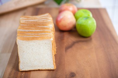 Tahtadaki beyaz ekmeği elmalarla dilimle ve muzu da mutfakta bir kase taze yeşil salatayla, sağlıklı gıda konseptiyle..