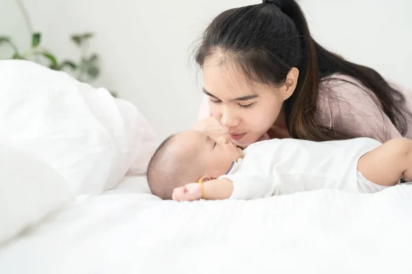 아름답고 아시아인 어머니는 침대에서 태어난 아기에게 맞추었다 서비스와 서비스 방식을 — 스톡 사진