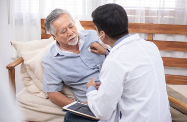 Kafkasyalı doktor dizüstü bilgisayarı kullan ve eski Asyalı erkek hastayla hastalık belirtileri hakkında konuş..