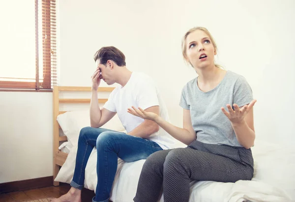 Unhappy young couple arguing, offended affronted woman ignoring angry man sitting her back to jealous husband shouting at frustrated wife, family fight at home, bad marriage relationships concept