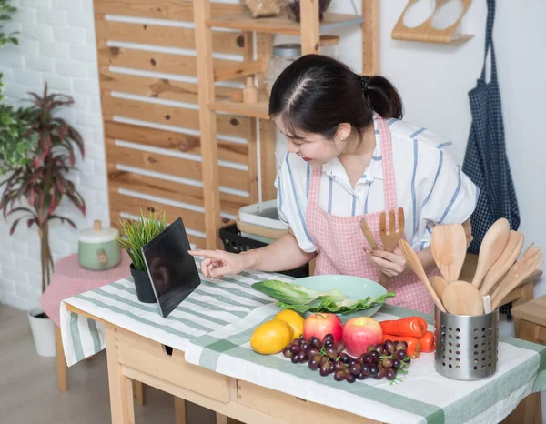 Happy asian woman looking recipe tablet kitchen reading cooking at home,University colleague student study online with social media,Social distancing, stay at home and work from home concept.