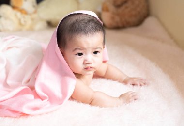 Yatakta yatarken ayaklarını sallayan tanınmayacak kadar tatlı bir bebeğin yakından çekimi, masumiyet bebek gelişimi kavramı.