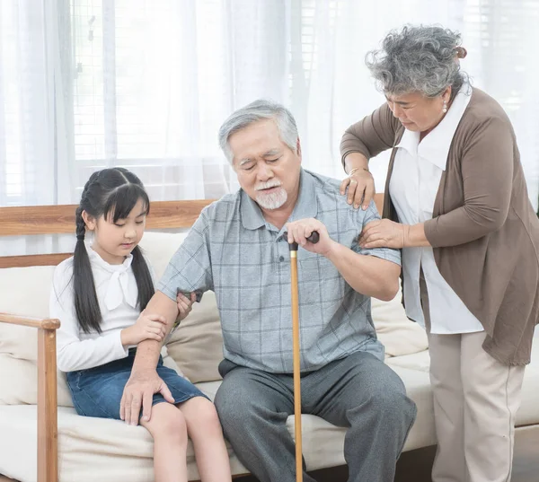 Asyalı büyükbaba, büyükannesiyle torununa yardım edip onu kanepede, emeklilik konseptine taşıdı..