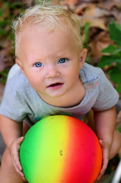 Grimy kid holding colorful ball — Stock Photo, Image