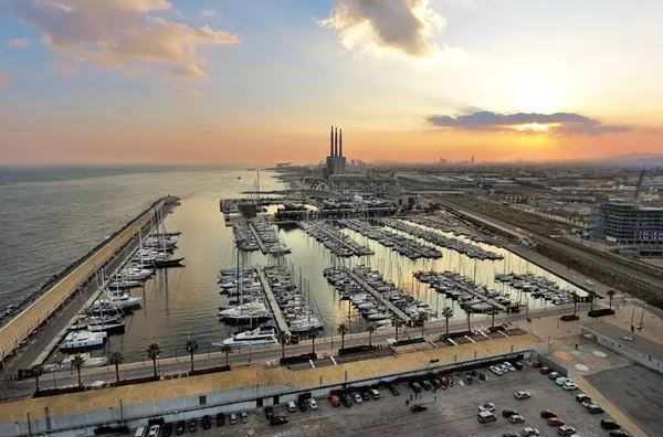 在巴塞罗那东部巴达洛纳的日落空中摄影 著名的三管道 海港和游艇俱乐部是可见的 免版税图库图片