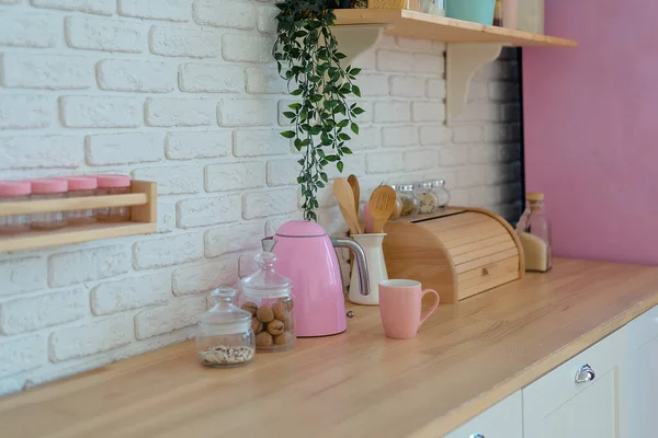 Modern kitchen with white wall, wooden counter top, breadbasket, shelves and pink fridge. Стиль жизни украшения кухни — стоковое фото