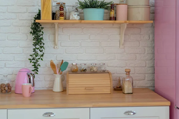 Modern kitchen with white wall, wooden counter top, breadbasket, shelves and pink fridge. Стиль жизни украшения кухни — стоковое фото
