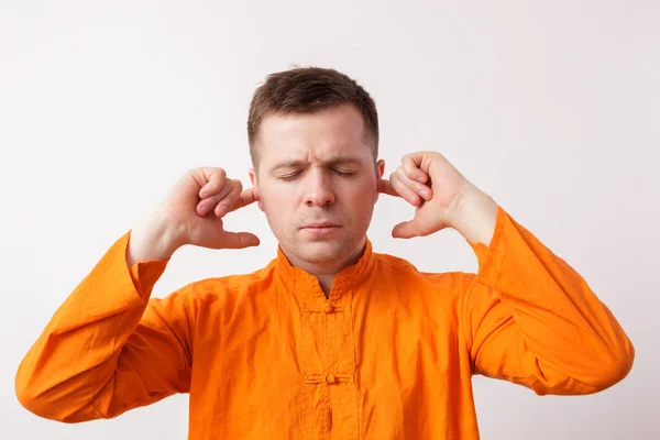 Young man buddhist in an orange shirt trying to focus — Stock Photo, Image