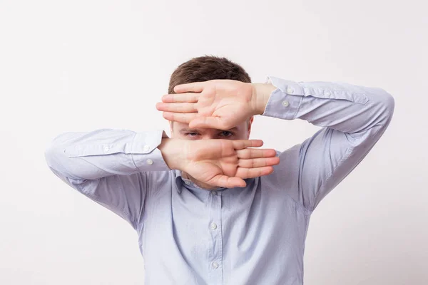 Man heeft betrekking op zijn gezicht met handen en kijken door een spleet — Stockfoto