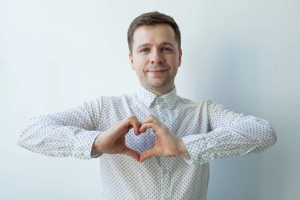 Kaukasische jongeman van handen hart te maken. Het doen van liefdadigheidswerk, zorg voor de gezondheid of verliefdheid — Stockfoto