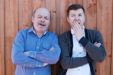 Ahşap duvar tarafından ayakta damat ve kayınpeder. Bunlar yorgun ve bıkkın.