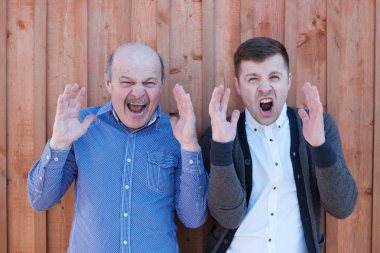 Yaşlı baba ve genç enişte dehşet içinde el sallayarak bağırmak. Ne gördüm gelen şok edici, maç sonuçları hakkında merak.