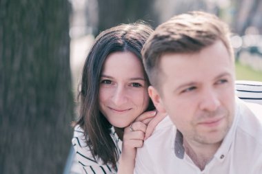 Genç bir çift dışında ve dinlenme bankta oturuyor. Bir erkek ve bir kadın arasındaki gerçek dostluk