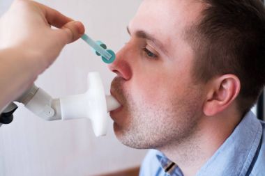 Genç adam tarafından Spirometri solunum fonksiyon testi.