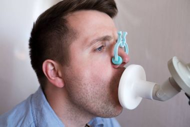 Genç adam tarafından Spirometri solunum fonksiyon testi.