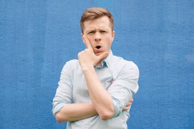 Şoka girmiş bir mavi tişörtlü adam ağız açılır. Sürpriz görünüyor ileri