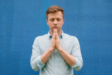 Meditasyon veya avuç içi birlikte göğüs, Tanrı'ya dua mavi tişörtlü adam